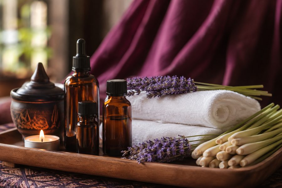 Essential oil bottles, lavender and folded towels ready for a relaxation massage